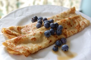 This is a crepe. Blueberries accent this French cuisine style. 