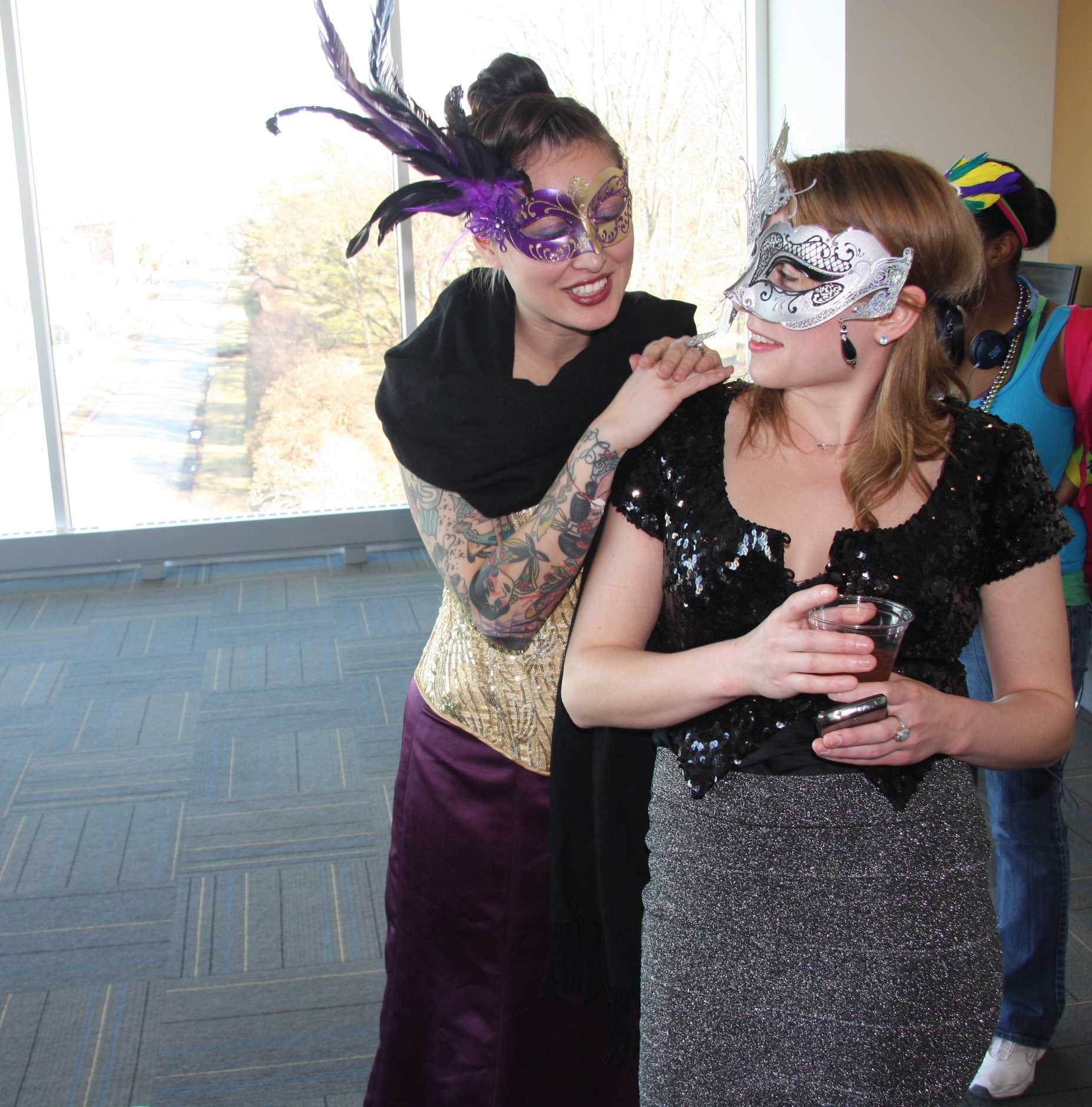 President Angela Fitle leans on treasurer Laura Schanzer’s shoulder. The two girls dress in Venetian-style masks and sequins to celebrate the season of Carnival.