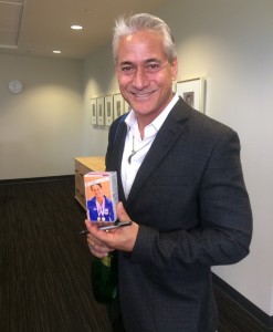 Louganis holds a small cereal box with his picture on it.