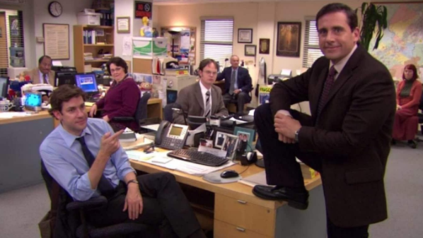 Several main characters from the famous show The Office standing around set and looking at the camera.