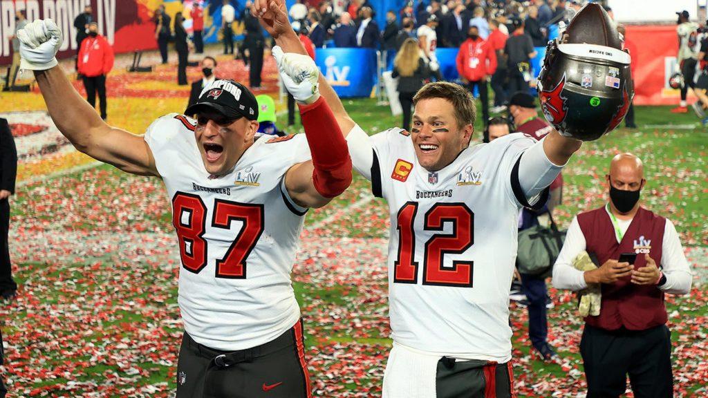 Tom Brady, quarterback for the Tampa Bay Buccaneers, cheering next to one of his teammates with confetti around them after the winning call for the Super Bowl game