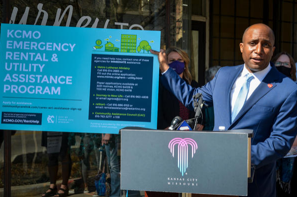 Kansas City Mayor Quinton Lucas standing behind a podium and in front of a sign explaining the new relief grant for Kansas City citizens struggling to pay their rent and/or utilities