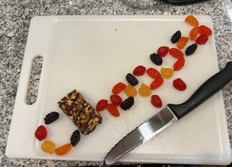Fruit snacks and a protein bar lined up to spell “chopped.”