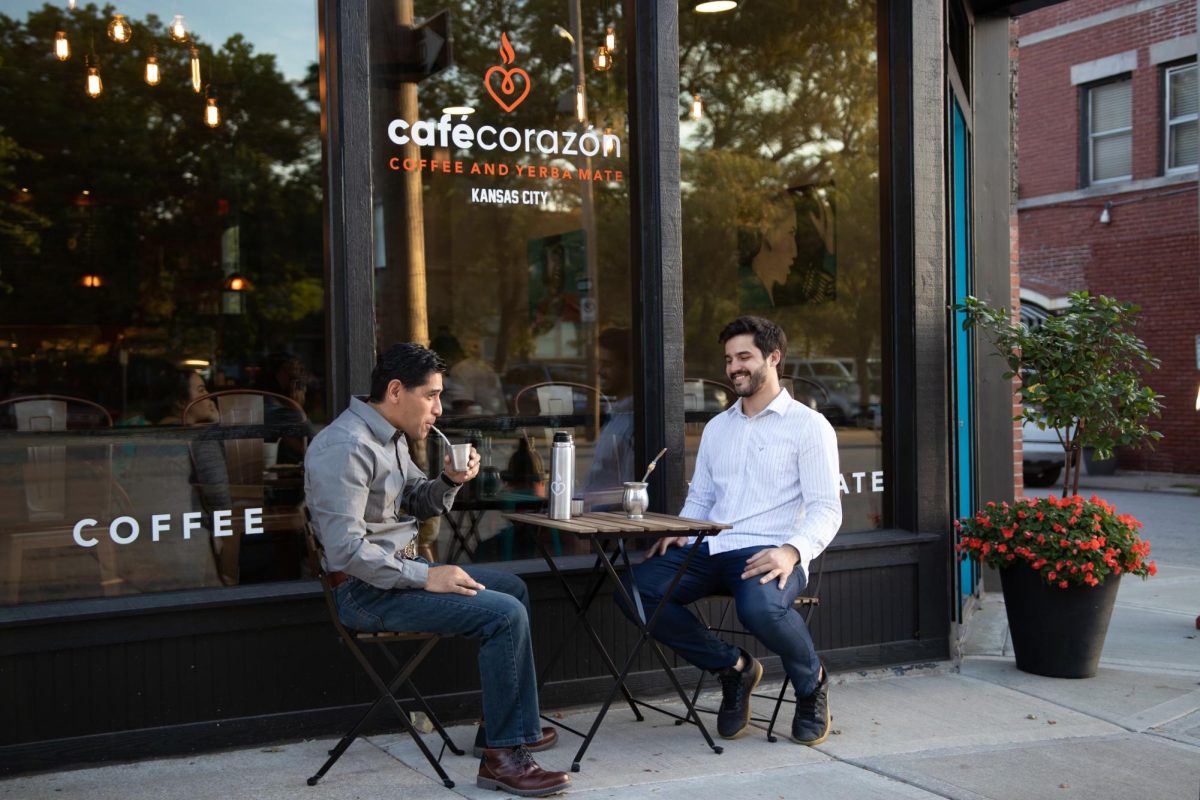 Two+guests+enjoying+coffee+at+the+front+of+Cafe+Corazon.+