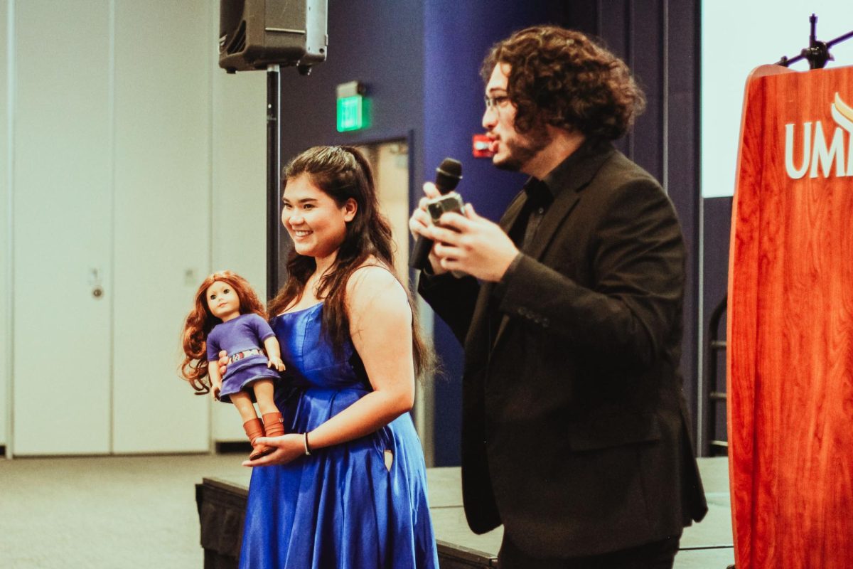 Caitlyn Ayala (left) holding her “last doll” as Marlon Perez-Morales (right) explains the custom.