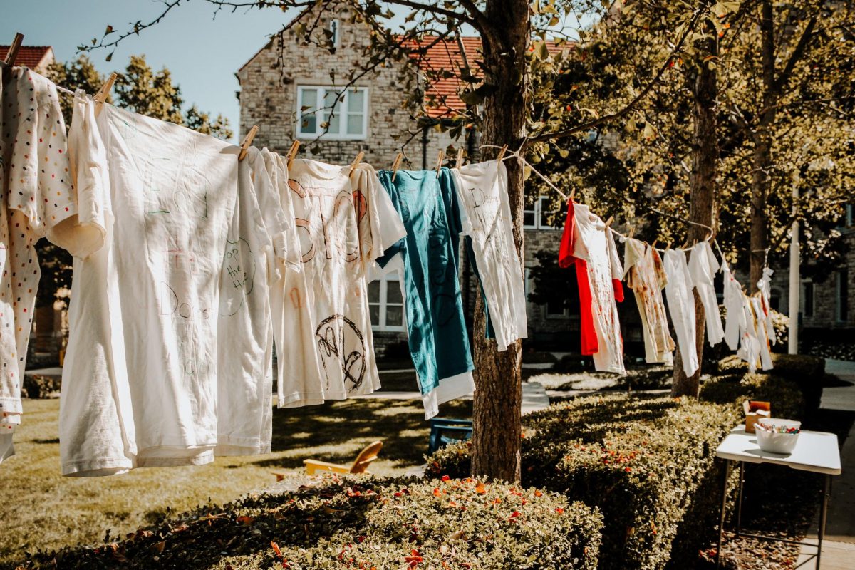 Clothesline hanging in the quad full of t-shirts of victims stories. 
