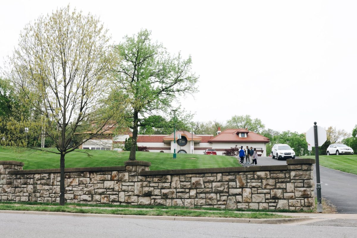 Located at the top of the hill, the National Museum of Toys and Miniatures  sits while students chat on the road headed down.