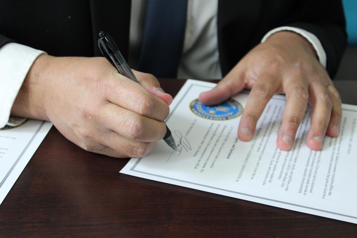 SGA President Justice Horn signing an executive order. 