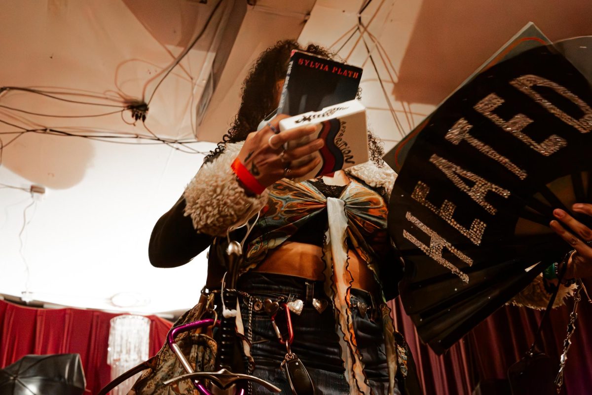 One of the contestants for the “femme” category donned a laundry list of props, including The Bell Jar, oversized carabiners, and a decorative sword. They won as the most “performative femme.” 