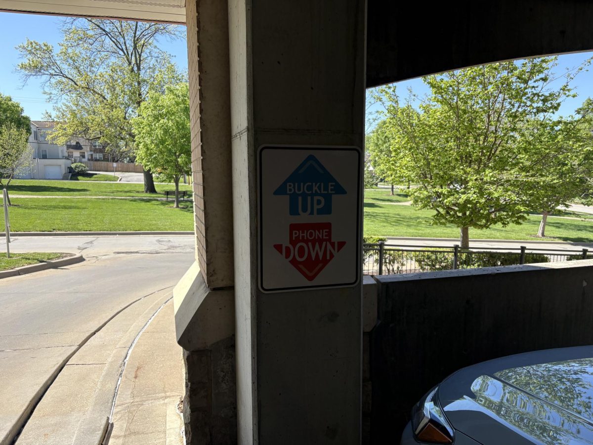 Shot of the sign located at the upper exit of Rockhill parking garage. This sign emphasizes the motto “Buckle Up” and “Phone Down” with their respective arrows pointing.