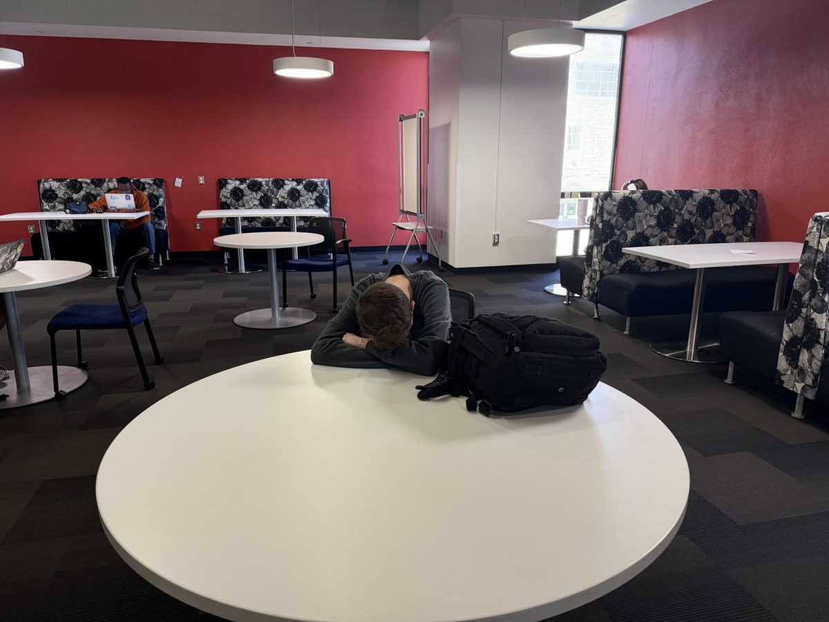 Alone or lonely? A UMKC student quietly lounges in Miller Nichols Library alone, increasing the normalization of navigating college life alone. 